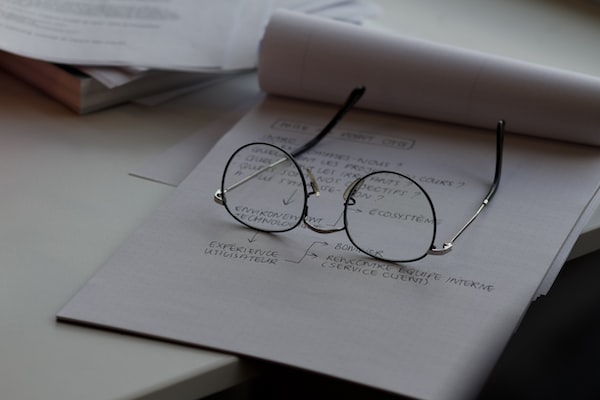 A mental health professional's notes and glasses from a CBT session.